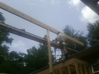 Carpenter setting a ridge beam over a new addition frame — Ice Dam Removal by Roofing Brothers in Waxhaw