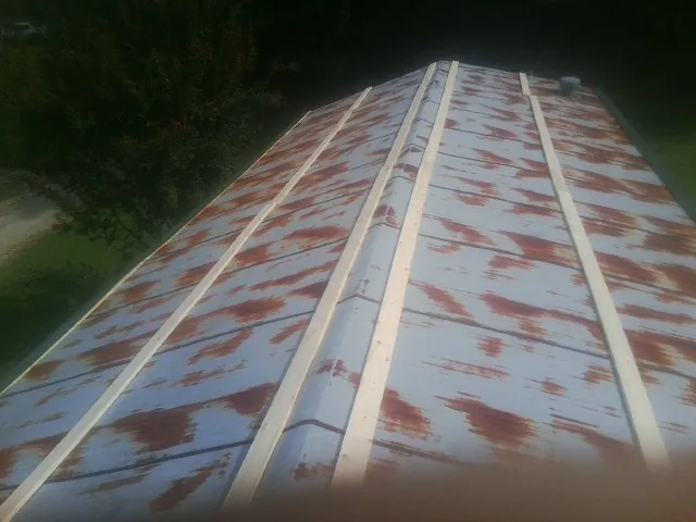 Rusted metal roof panels with new wood purlins before replacement — Storm Damage Roof Repair in Waxhaw by Roofing Brothers