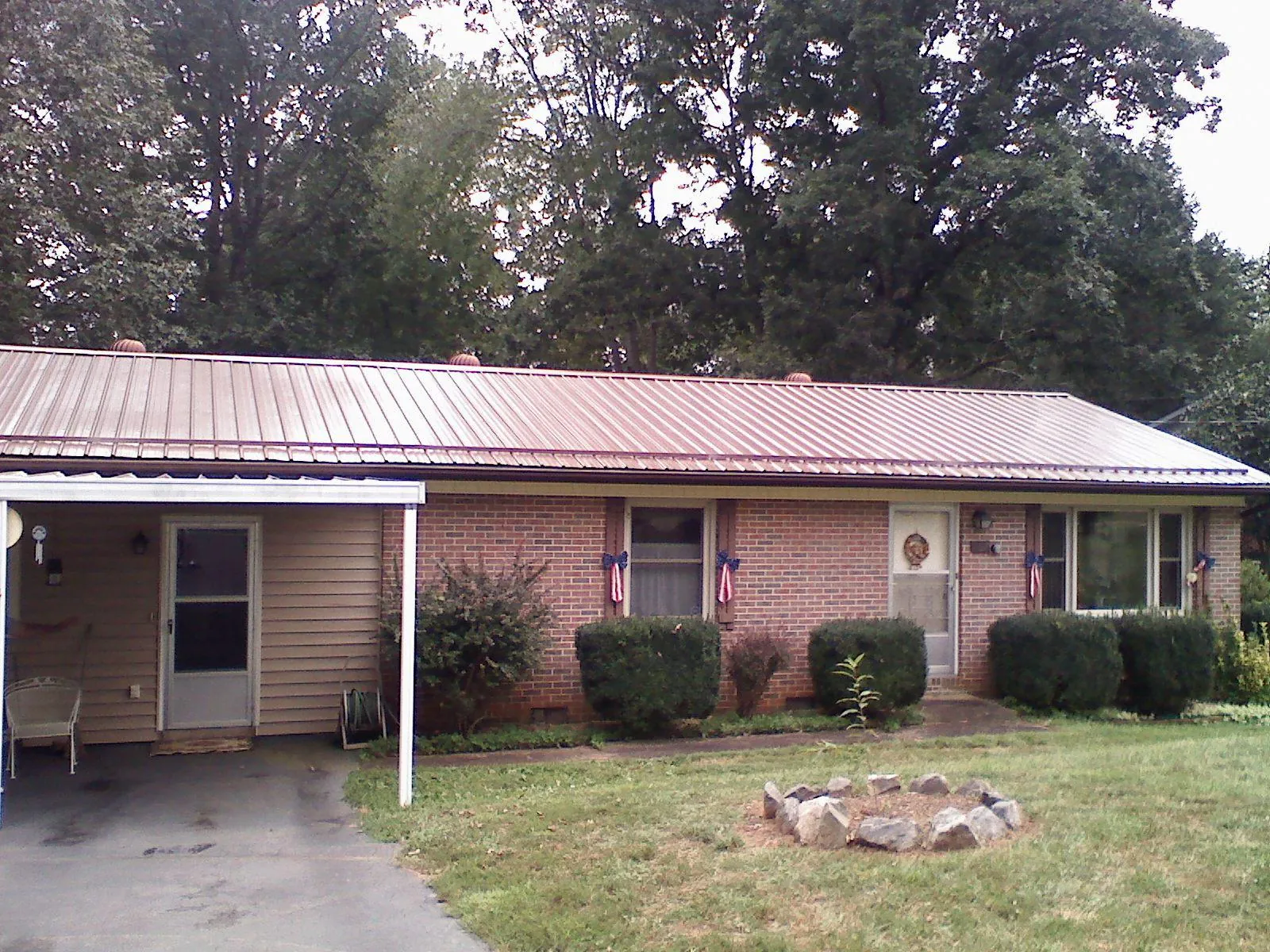 Bronze metal roof and carport on a brick ranch home — Roof Repair work by our crew in Waxhaw