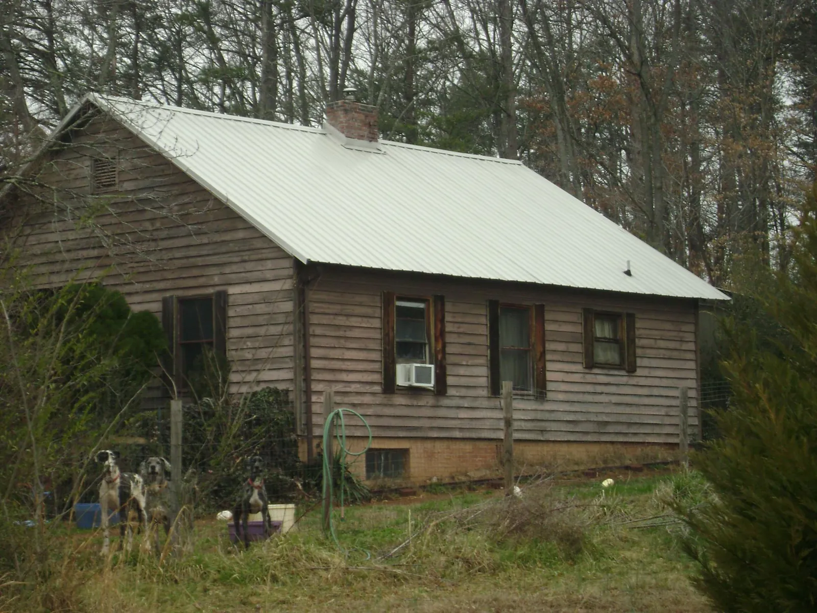 White metal roof on an old wood sided farmhouse, from a Metal Roof Installation job in Waxhaw